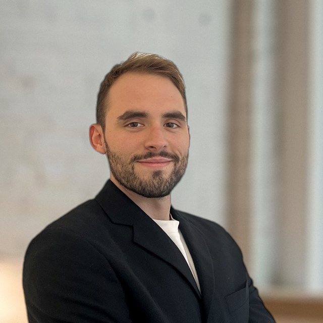 Max Chéneau, fondateur de l'Agence Talos, en veste noire, souriant et bras croisés